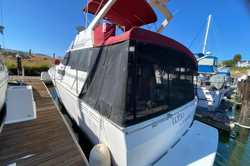 Slide: The Image of 1989 Bayliner 3888 Motoryacht docked, featuring red canopy and black mesh enclosure. - 4