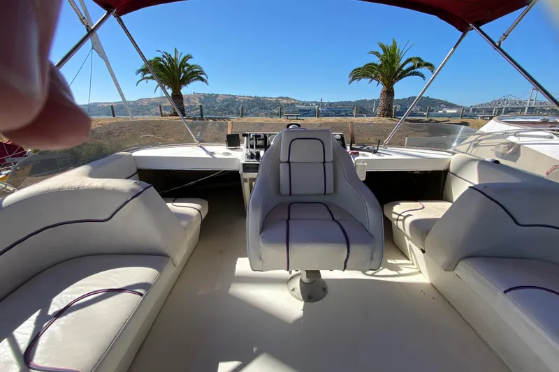 Slide: The Image of 1989 Bayliner 3888 Motoryacht interior with seating, helm, and scenic waterfront view. - 5