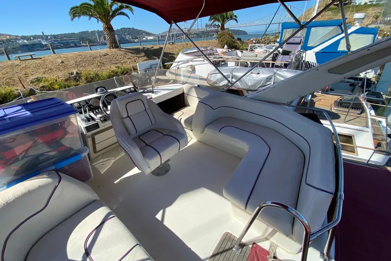 Slide: The Image of 1989 Bayliner 3888 Motoryacht interior with seating, steering, and scenic waterfront view. - 7