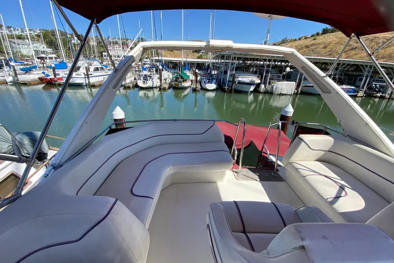Slide: The Image of 1989 Bayliner 3888 Motoryacht with spacious seating, docked at a marina with multiple boats. - 8