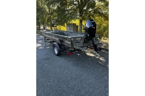 Slide: The Image of 2026 Tracker Grizzly 1654 T Sportsman boat on trailer, parked outdoors. - 2