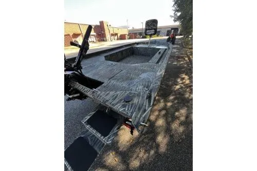 Slide: The Image of 2026 Tracker Grizzly 1654 T Sportsman boat with camouflage design on a sunny day. - 6