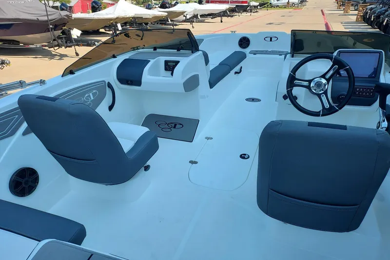 Slide: The Image of 2026 Tahoe T21 boat interior with modern steering and seating, docked outdoors. - 3