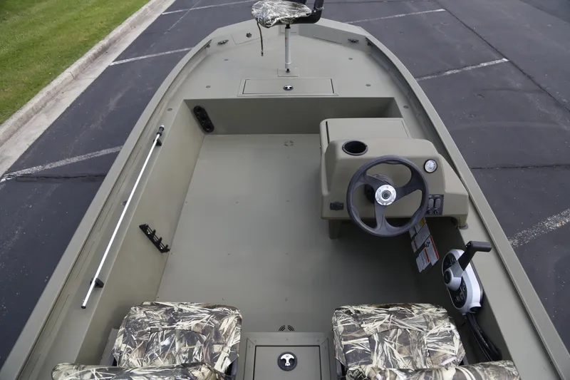 Slide: The Image of 2026 Tracker Grizzly 1754 SC boat interior with camo seats and steering console. - 4