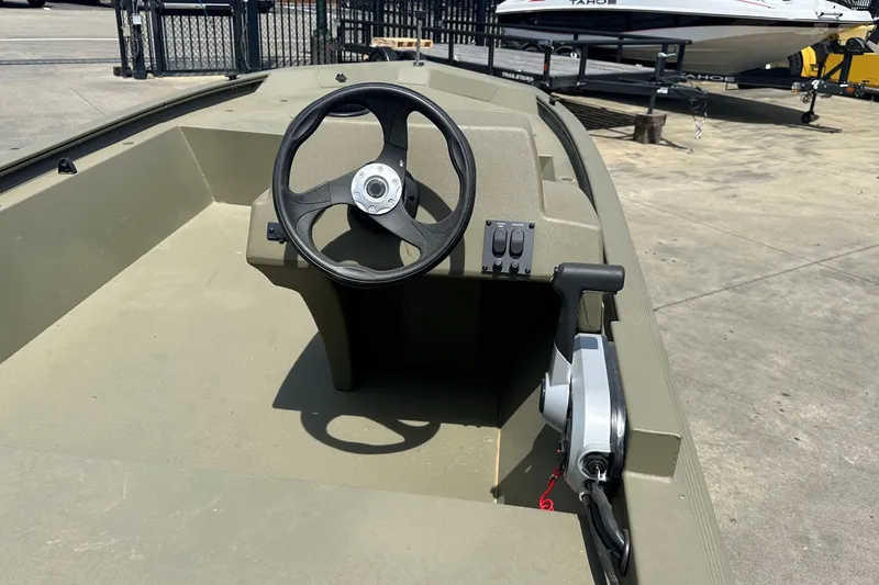 Slide: The Image of 2026 Tracker Grizzly 1648 SC boat interior with steering wheel and controls. - 3