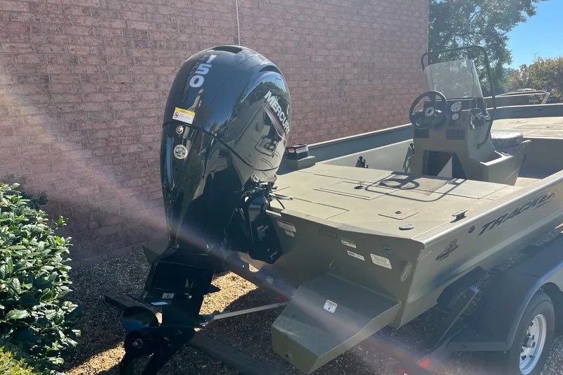 Slide: The Image of 2025 Tracker Grizzly 2072 CC boat with Mercury 150 outboard motor, parked outdoors. - 6