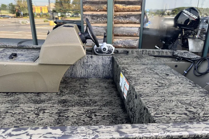 Slide: The Image of 2026 Tracker Grizzly 1648 SC boat interior with camouflage design and Mercury engine. - 3