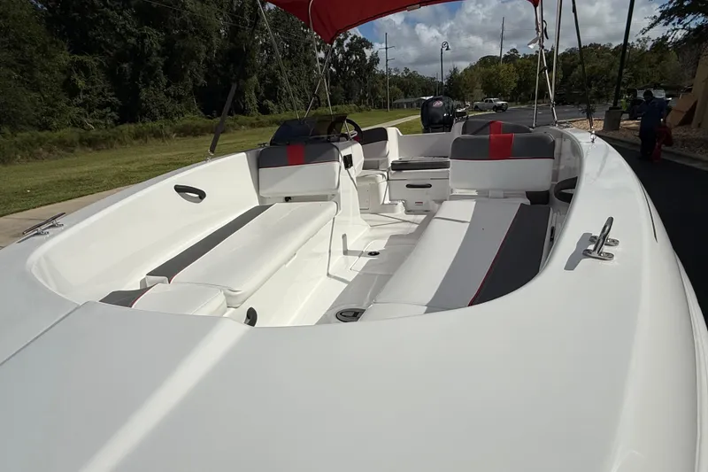 Slide: The Image of 2026 Tahoe T18 boat interior with white and red seating, parked outdoors. - 2