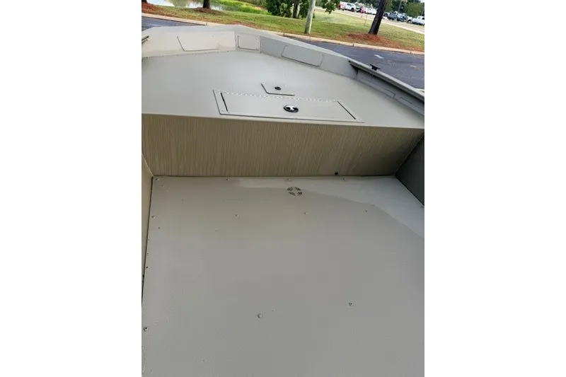 Slide: The Image of 2026 Tracker Grizzly 1754 Utility boat interior with storage compartment, parked outdoors. - 7