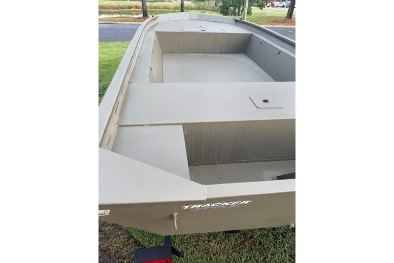 Slide: The Image of 2026 Tracker Grizzly 1754 Utility boat, beige color, parked on grass. - 5