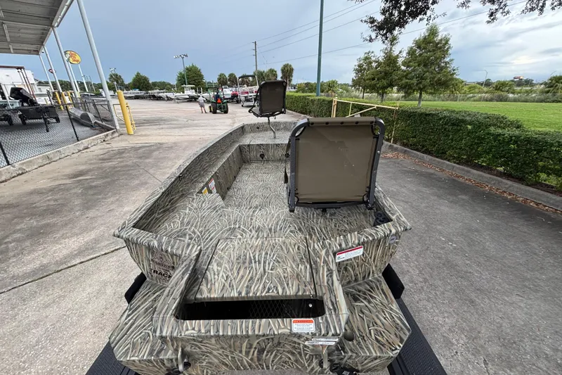 Slide: The Image of 2026 Tracker Grizzly 1650 T Prairie Wings Edition boat with camouflage design, parked outdoors. - 3