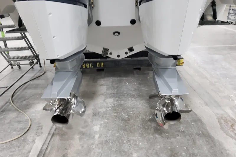 Slide: The Image of 2026 Formula 380 Super Sport Crossover OB outboard motors with dual propellers in a workshop. - 31