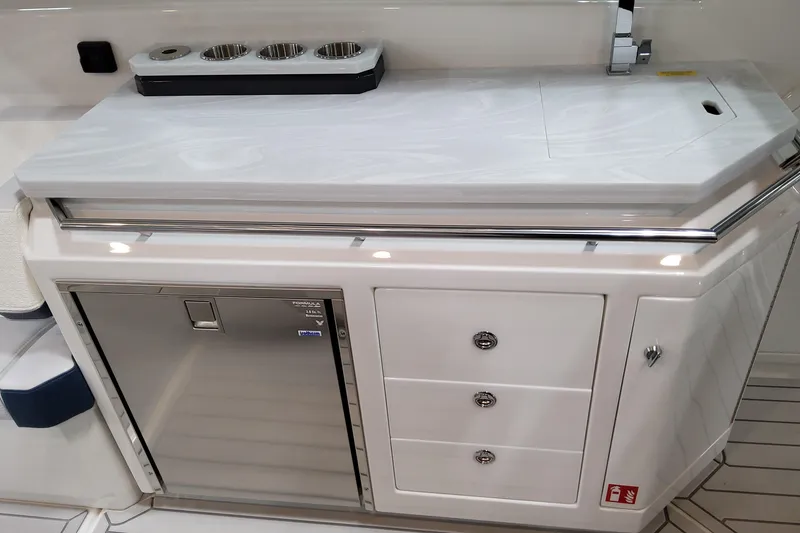 Slide: The Image of 2026 Formula 380 Super Sport Crossover OB boat interior with sleek kitchenette and storage. - 75