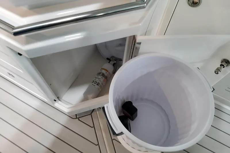 Slide: The Image of Open storage compartment on 2026 Formula 380 Super Sport Crossover OB boat, featuring a fire extinguisher. - 76