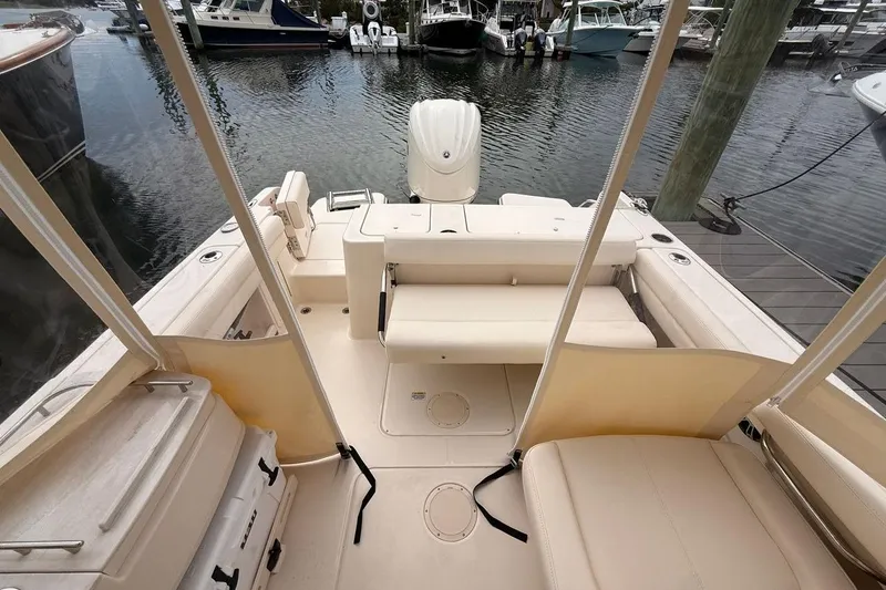 Slide: The Image of 2025 Grady-White Freedom 235 boat interior at marina, showcasing seating and deck layout. - 11