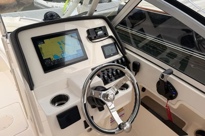 Slide: The Image of 2025 Grady-White Freedom 235 boat dashboard with navigation system and controls. - 4