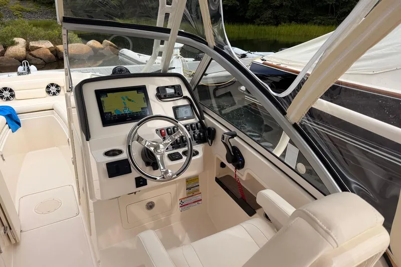 Slide: The Image of 2025 Grady-White Freedom 235 boat interior with modern navigation system and steering wheel. - 5