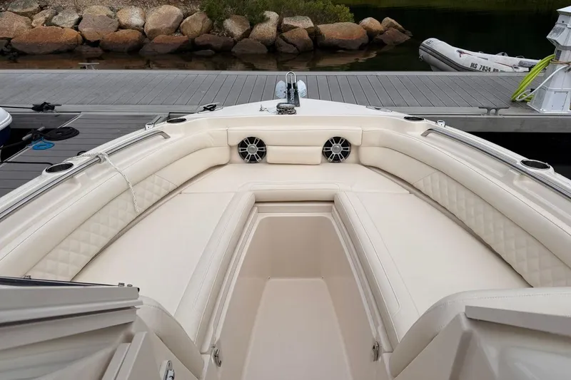 Slide: The Image of Luxurious seating area on 2025 Grady-White Freedom 235 boat, docked by rocky shoreline. - 6
