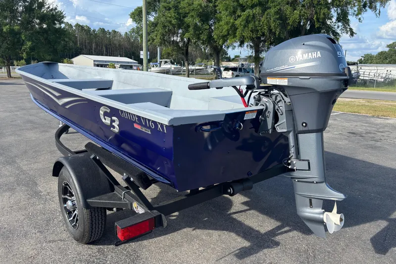 Slide: The Image of 2025 G3 Guide V16 XT boat with Yamaha motor on trailer, parked outdoors. - 17