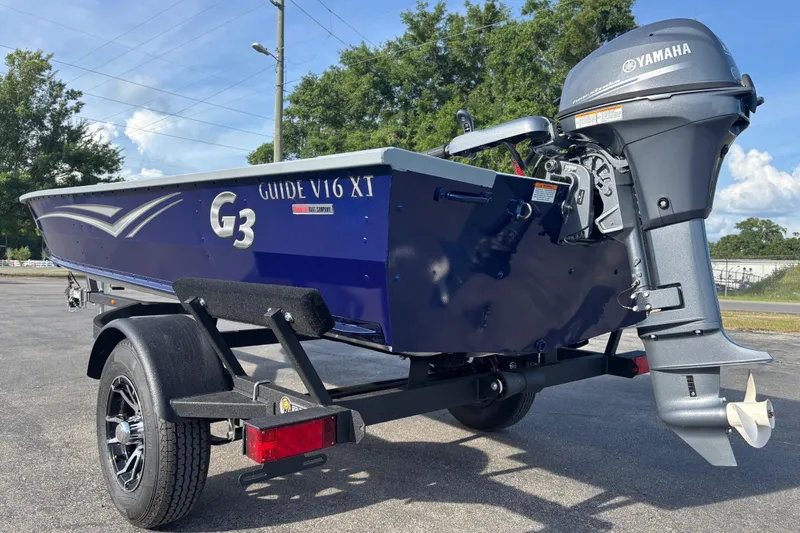Slide: The Image of 2025 G3 Guide V16 XT boat with Yamaha outboard motor on a trailer. - 18