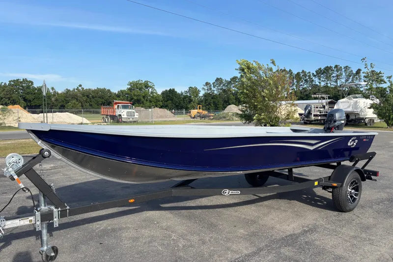 Slide: The Image of 2025 G3 Guide V16 XT boat on trailer, parked outdoors under clear sky. - 8