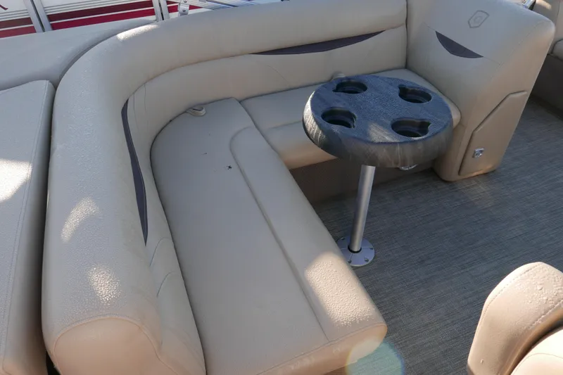 Slide: The Image of 2018 Sweetwater SW2086c boat interior with beige seating and cupholder table. - 13