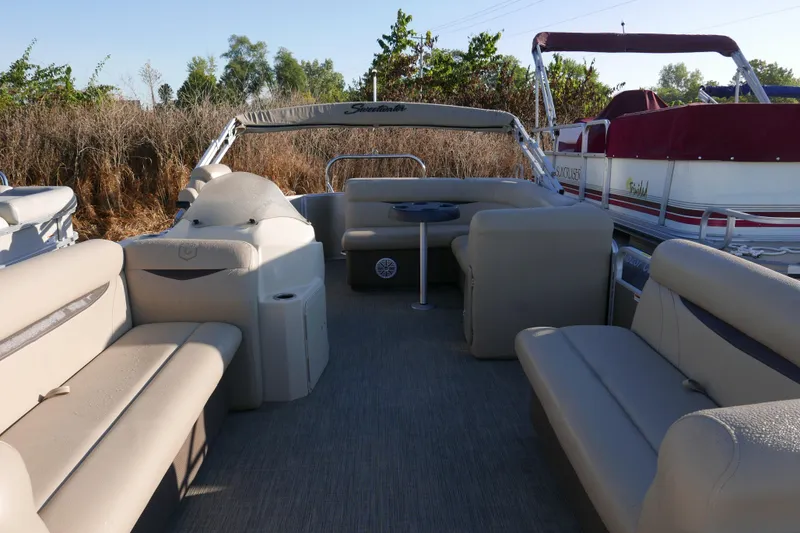 Slide: The Image of 2018 Sweetwater SW2086c pontoon boat interior with beige seating and table. - 6