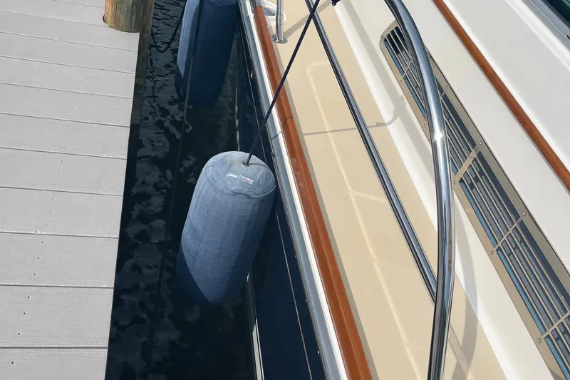 Slide: The Image of 2012 Sabre 42 Salon Express docked with fenders, showcasing sleek design and polished railings. - 31