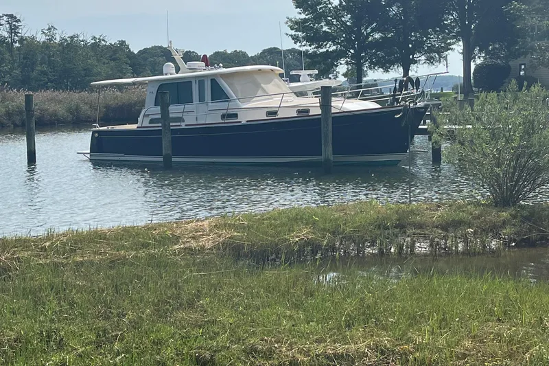 Slide: The Image of 2012 Sabre 42 Salon Express yacht docked in a serene, wooded marina setting. - 33