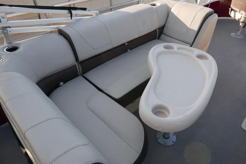 Slide: The Image of 2018 SUNTRACKER Fish N Barge 20 interior with cushioned seating and table. - 10