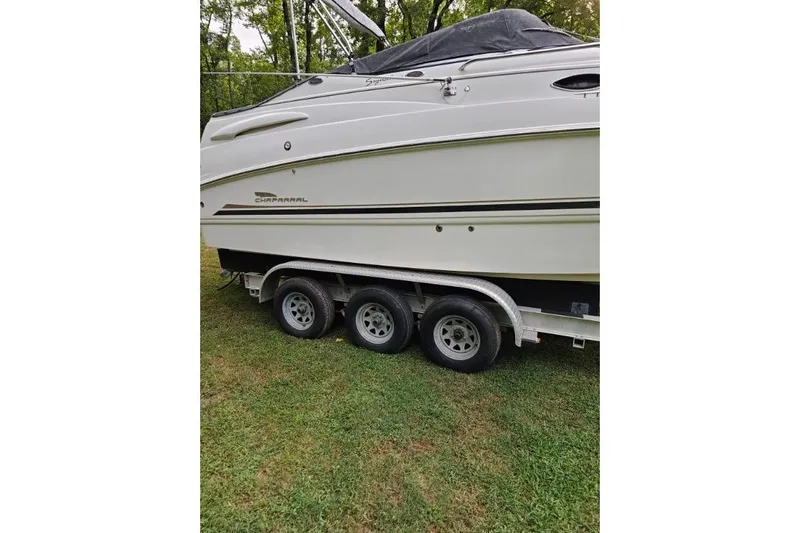 Slide: The Image of 2002 Chaparral Signature 240 boat on a triple-axle trailer, parked on grass. - 2