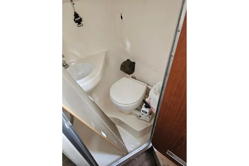 Slide: The Image of Compact bathroom in 2002 Chaparral Signature 240 boat, featuring toilet and sink. - 9