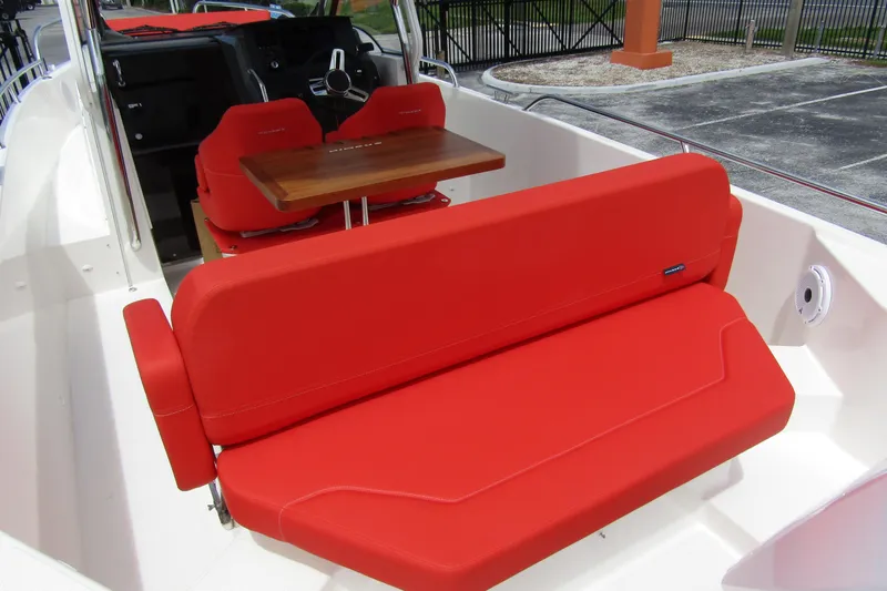 Slide: The Image of 2024 Nimbus T8 boat interior with vibrant red seating and wooden table. - 27