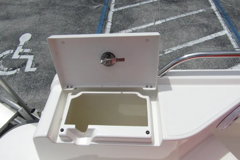 Slide: The Image of Open storage compartment on 2024 Nimbus T8 boat, with latch and railing visible. - 29