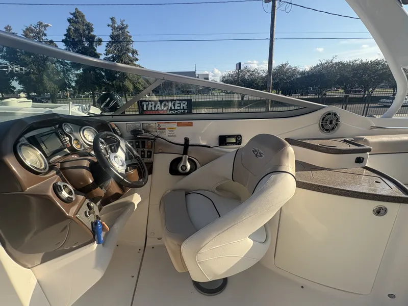 Slide: The Image of 2013 Rinker Captiva 276 boat with spacious seating, parked outdoors in sunlight. - 14