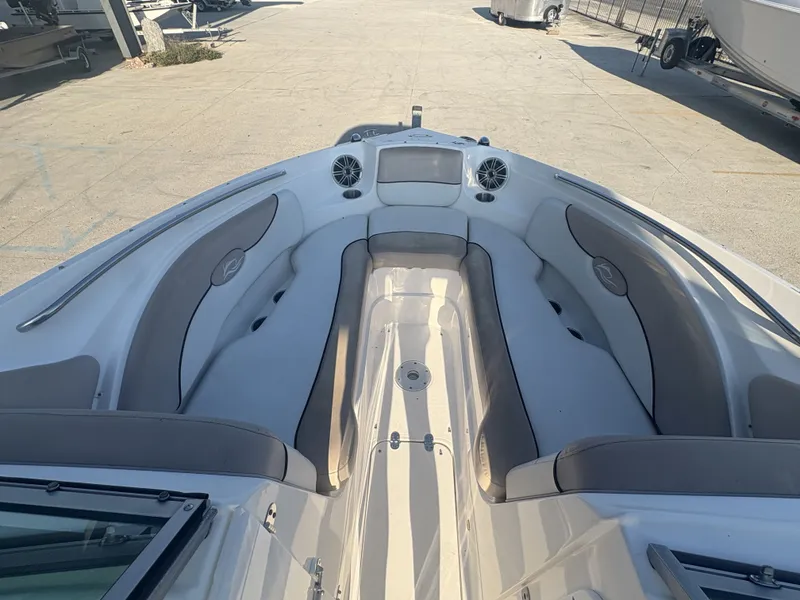 Slide: The Image of 2013 Rinker Captiva 276 boat with open seating, parked outdoors on a sunny day. - 15