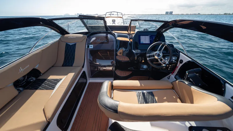 Slide: The Image of Luxurious 2025 Hanover 305 boat interior with tan leather seating and modern dashboard on open water. - 15