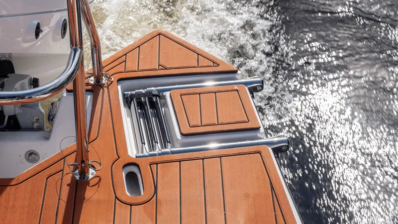 Slide: The Image of 2026 Hanover 305 boat deck with wooden finish and water backdrop. - 43