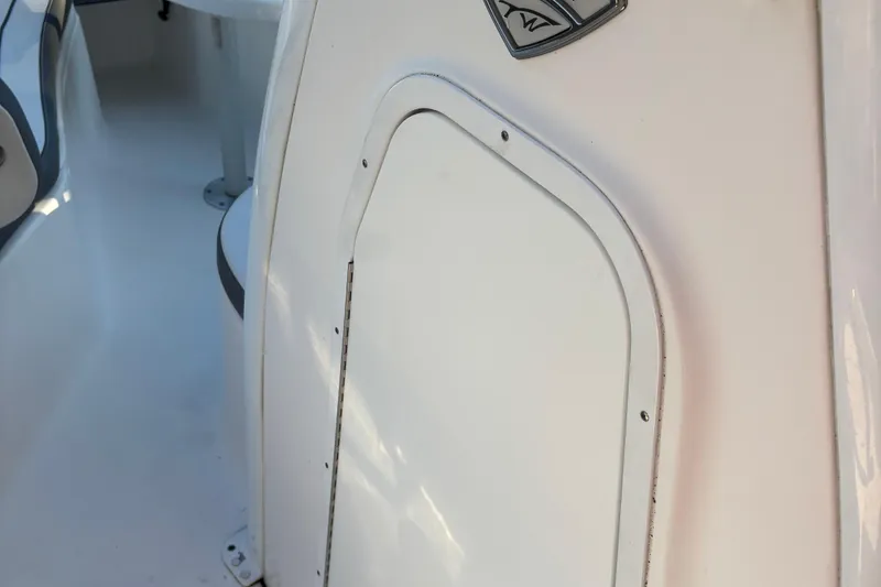 Slide: The Image of 2018 Tidewater 232 LXF boat interior detail, featuring a white panel and seating area. - 13