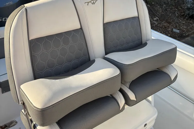 Slide: The Image of 2018 Tidewater 232 LXF boat seats with gray and white cushioned design. - 14