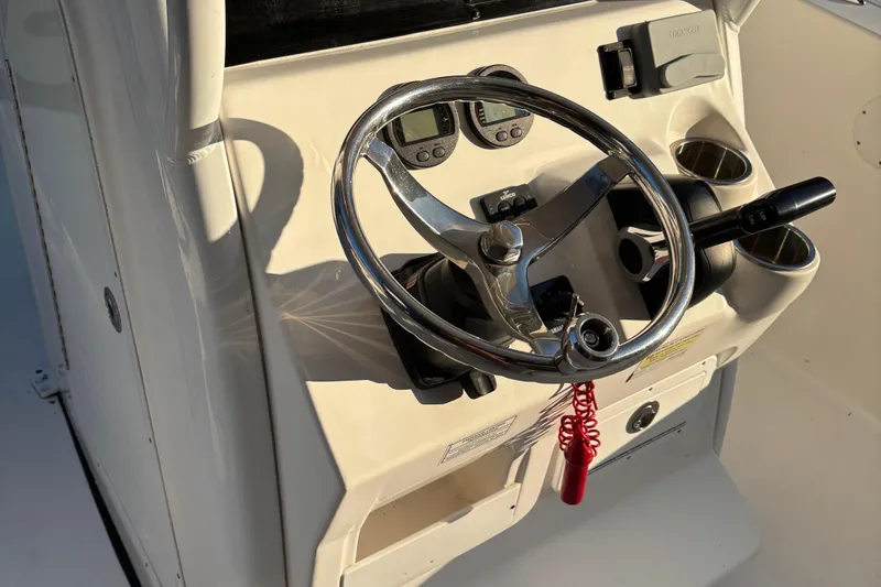 Slide: The Image of Steering console of 2018 Tidewater 232 LXF boat with chrome wheel and controls. - 16