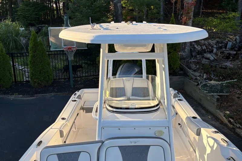 Slide: The Image of 2018 Tidewater 232 LXF boat with T-top, parked near trees and a basketball hoop. - 24