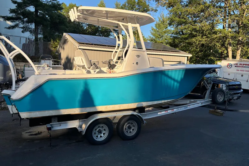 Slide: The Image of 2018 Tidewater 232 LXF boat on trailer, vibrant blue hull, parked outdoors. - 3