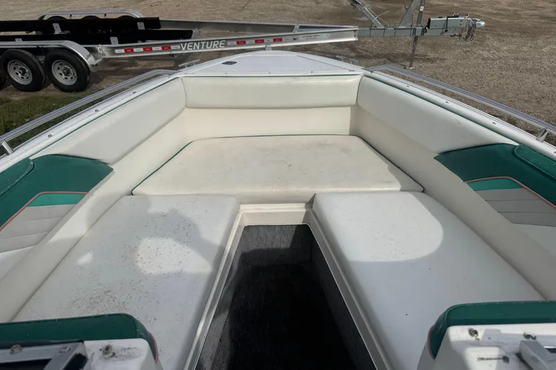 Slide: The Image of 1991 Sea Ray 220 boat interior with white and green seating, trailer visible in background. - 3