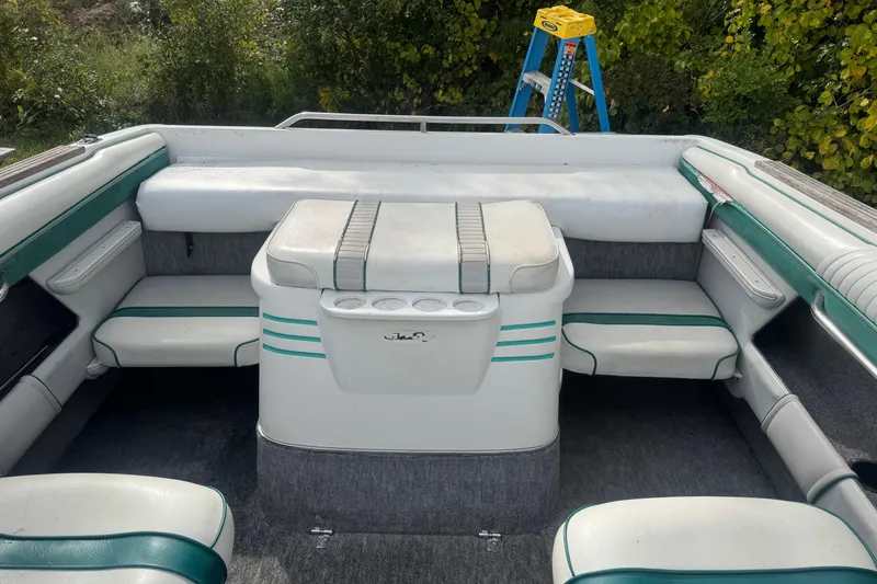 Slide: The Image of Interior of a 1991 Sea Ray 220 boat with white and green seating. - 4