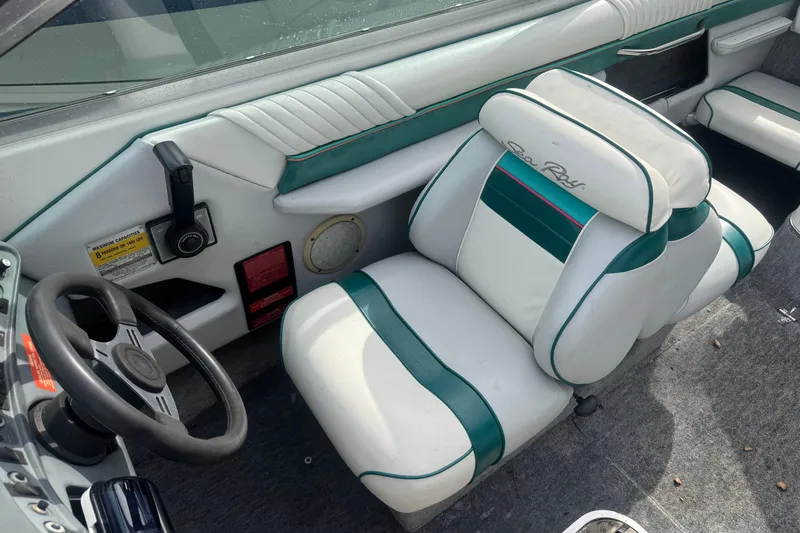Slide: The Image of 1991 Sea Ray 220 boat interior with white and green seating, steering wheel, and dashboard controls. - 6