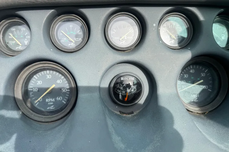 Slide: The Image of Dashboard of a 1991 Sea Ray 220 boat with various gauges and a compass. - 8