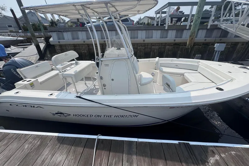 The Image of 2024 Cobia 220 Center Console boat cruising on open water with Seakeeper Ride logo. - 0