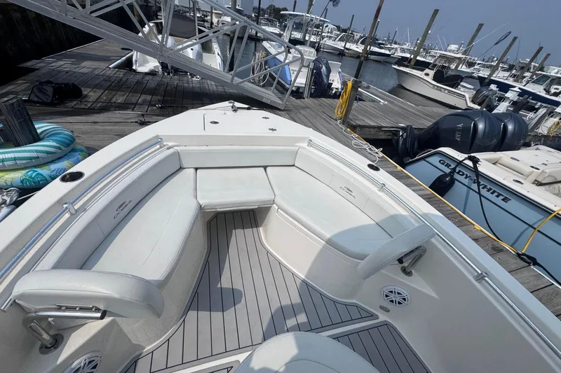 Slide: The Image of 2024 Cobia 220 Center Console boat docked, featuring spacious seating and modern design. - 6