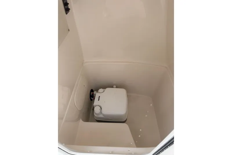Slide: The Image of 2024 Cobia 220 Center Console interior storage compartment with portable toilet. - 8